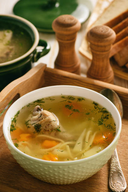 istock Chicken soup in bowl on wooden tray. 843608320