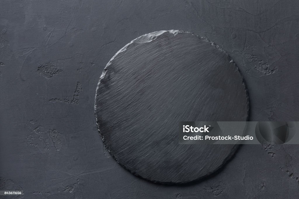 Empty rustic black slate stone plate on dark background Empty rustic black slate stone plate on dark background, copy space, top view Plate Stock Photo