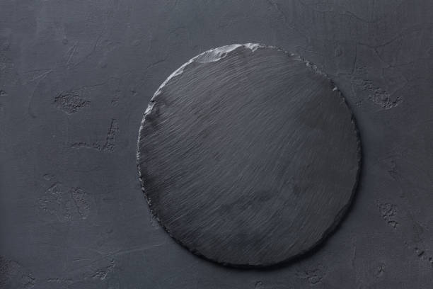 Empty rustic black slate stone plate on dark background Empty rustic black slate stone plate on dark background, copy space, top view pub table top view stock pictures, royalty-free photos & images