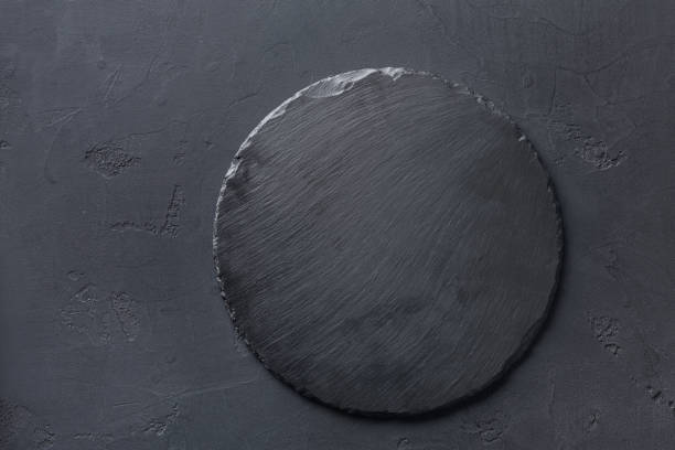empty rustic black slate stone plate on dark background - circle of stones imagens e fotografias de stock