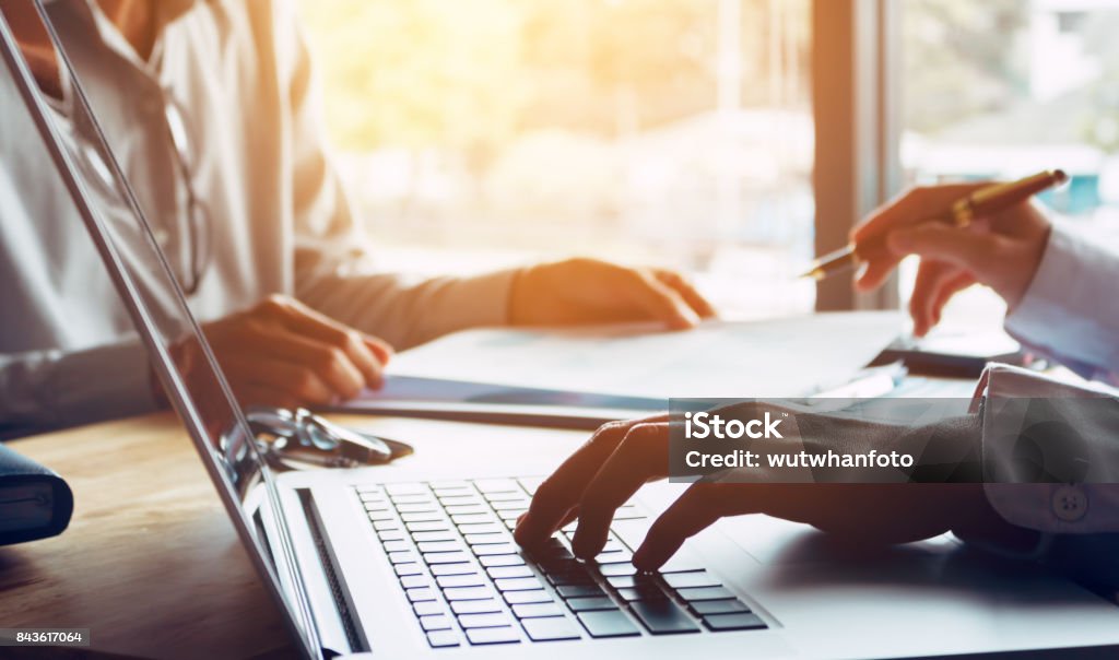 Business people or doctor talking to customer and using laptop at office room. Insurance Stock Photo