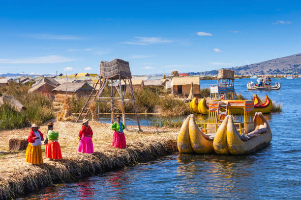 Titicaca lake, Puno PUNO, PERU - MAY 14, 2015: Unidentified women in traditional dresses welcome tourists in Uros Island. inca photos stock pictures, royalty-free photos & images
