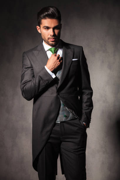istock young elegant man adjusting his green tie 843619668