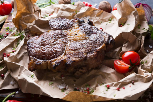 istock Rib eye steak on cooking paper, parchment close up 843619676