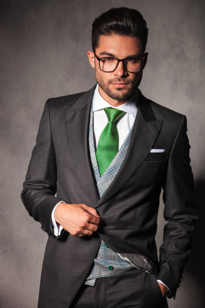 istock elegant young man in tuxedo jacket holding button 843619714