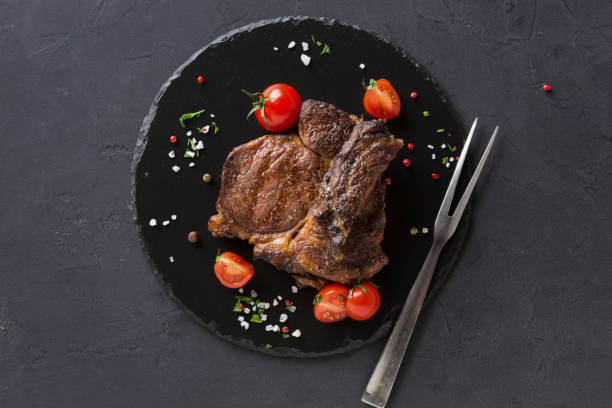 istock Rib eye steak on dark plate, top view 843619916