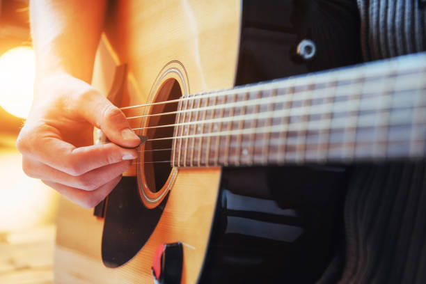 istock Guitarist plays guitar on wooden background, close up 843623748
