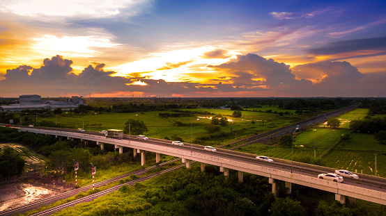 Aerial Photo Countryside Car Running on Road Bridge Over Railway and Golden Hour Sky Beautiful Landscape Drone View