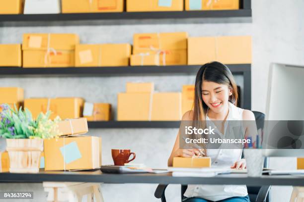 Young Asian Small Business Owner Working At Home Office Taking Note On Purchase Orders Online Marketing Packaging Delivery Startup Sme Entrepreneur Or Freelance Woman Concept Stock Photo - Download Image Now
