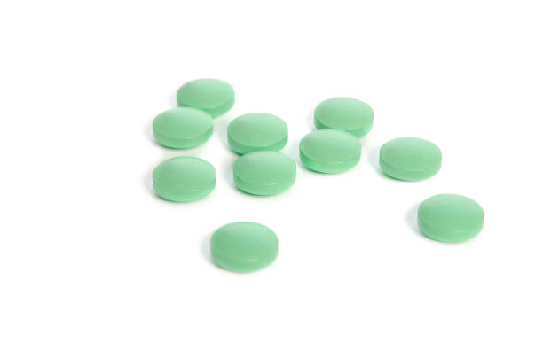 istock Pile of light green pills isolated on white background 843631798