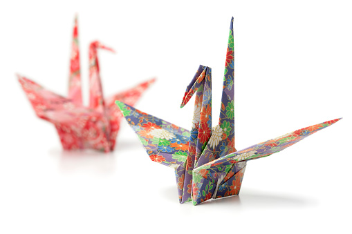 Two origami paper crane birds on white background