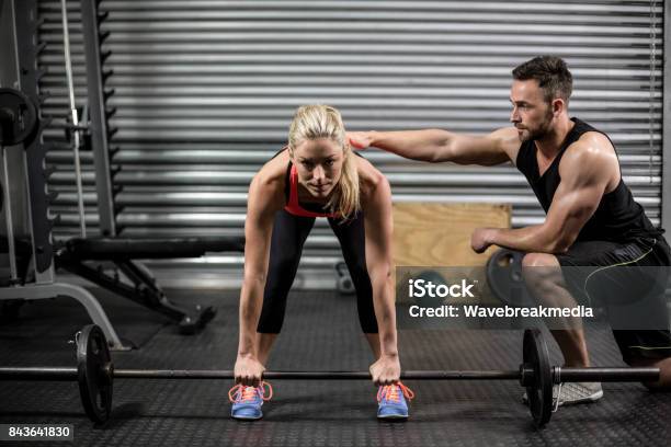 Trainer Helping Woman With Lifting Barbell Stock Photo - Download Image Now - 25-29 Years, 30-34 Years, 30-39 Years