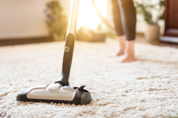istock Woman using a vacuum cleaner while cleaning carpet in the house. 843642648