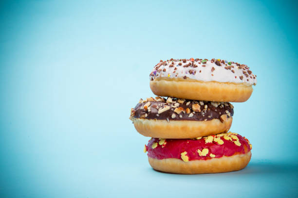 istock Donuts glazed with sprinkles on pastel blue background 843642768
