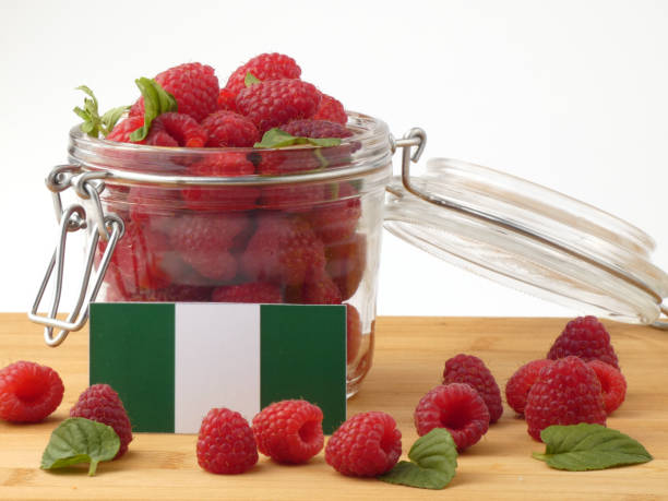 Nigerian flag on a wooden panel with raspberries isolated on a white background