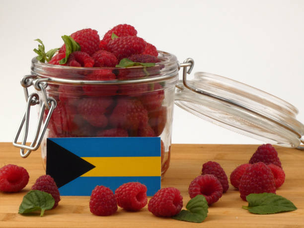 istock Bahamas flag on a wooden panel with raspberries isolated on a white background 843653260