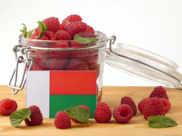 istock Madagascar flag on a wooden panel with raspberries isolated on a white background 843653356