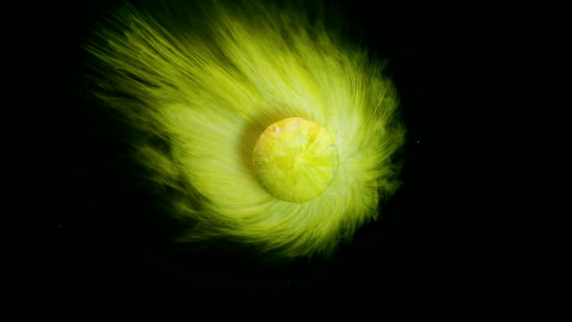 Amazing macro of yellow pill dissolving in water looking like a planet abstract background