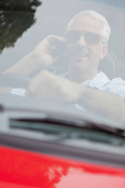 istock Cheerful handsome man in red convertible having phone call 843653656