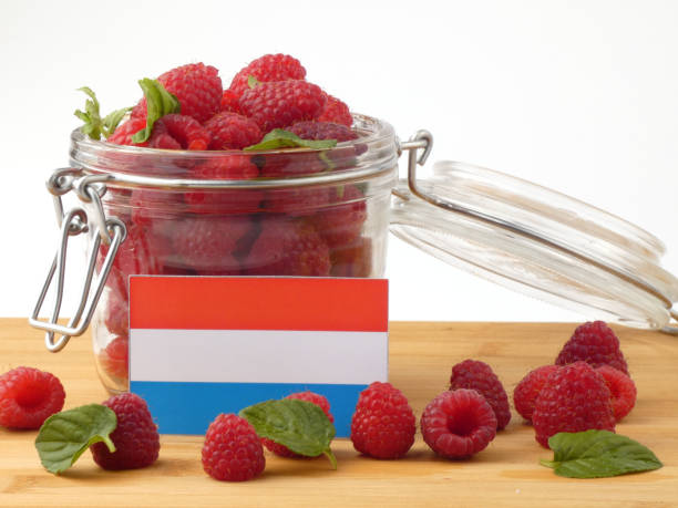 istock Luxembourg flag on a wooden panel with raspberries isolated on a white background 843653744