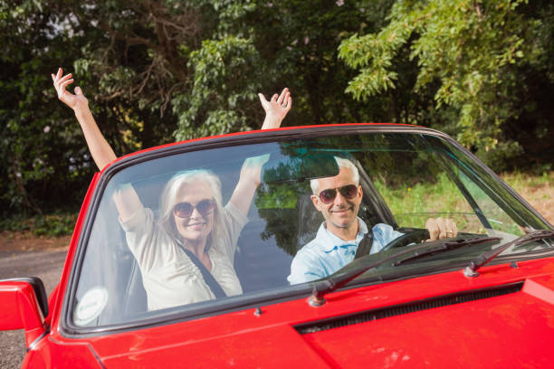 istock Mature couple in red cabriolet cheering at camera 843655522