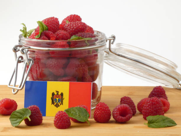 istock Moldovan flag on a wooden panel with raspberries isolated on a white background 843656726