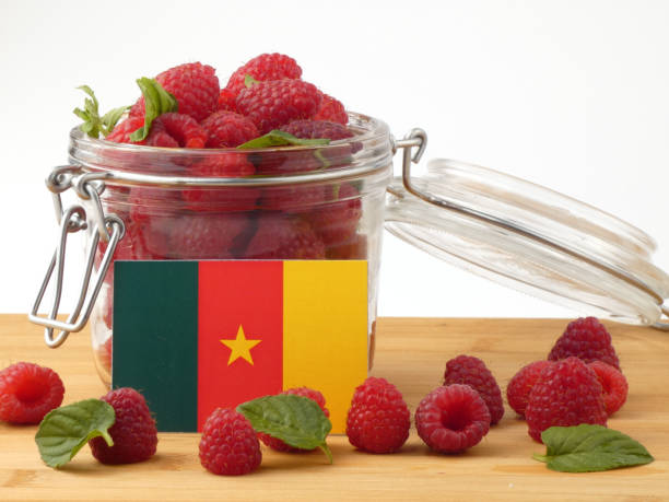 istock Cameroon flag on a wooden panel with raspberries isolated on a white background 843656942