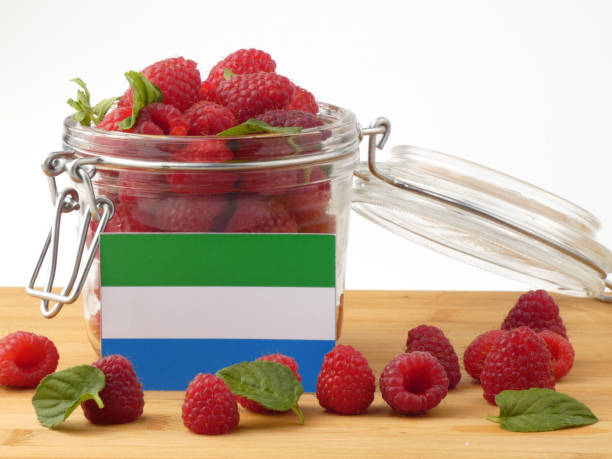 istock Sierra Leone flag on a wooden panel with raspberries isolated on a white background 843657050