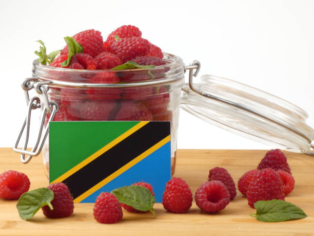 istock Tanzanian flag on a wooden panel with raspberries isolated on a white background 843657104