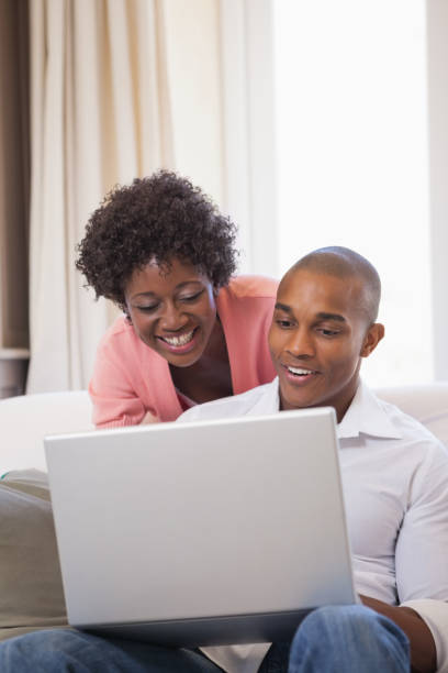 istock Happy couple relaxing on the couch with laptop 843657318