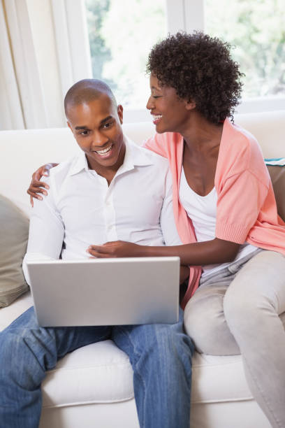 istock Happy couple relaxing on the couch with laptop 843657360