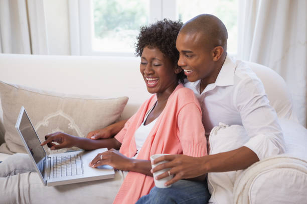 istock Happy couple relaxing together on the couch using laptop having coffee 843657534