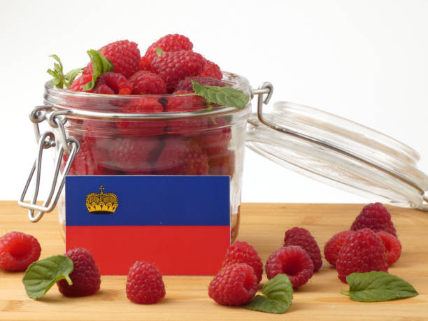 Liechtenstein flag on a wooden panel with raspberries isolated on a white background