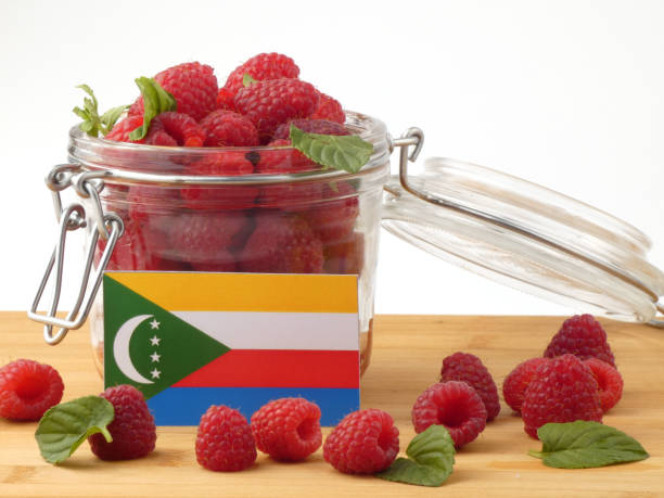 istock Comoros flag on a wooden panel with raspberries isolated on a white background 843657866