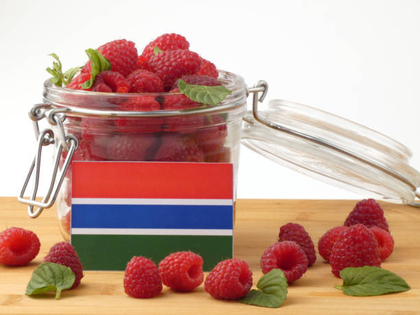 istock Gambia flag on a wooden panel with raspberries isolated on a white background 843658342