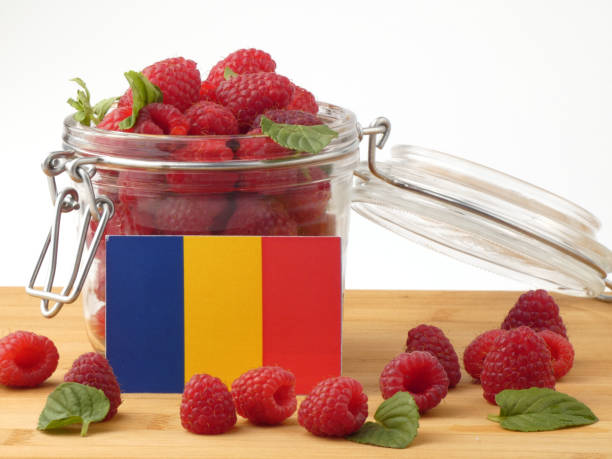 istock Romanian flag on a wooden panel with raspberries isolated on a white background 843658494