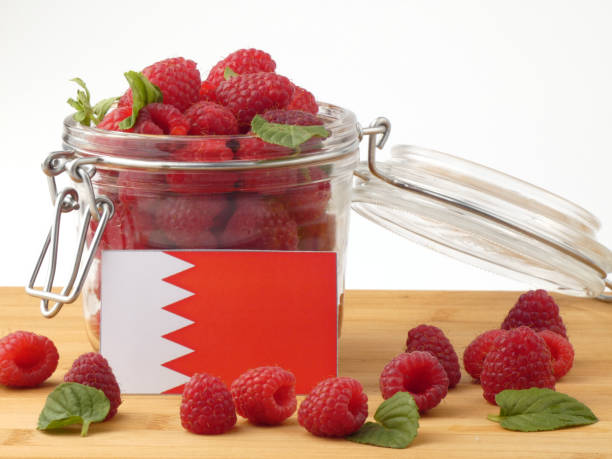 istock Bahrain flag on a wooden panel with raspberries isolated on a white background 843661126