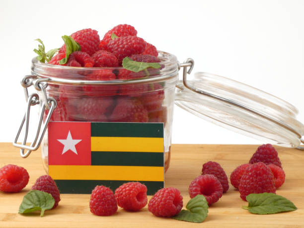 istock Togolese flag on a wooden panel with raspberries isolated on a white background 843661304