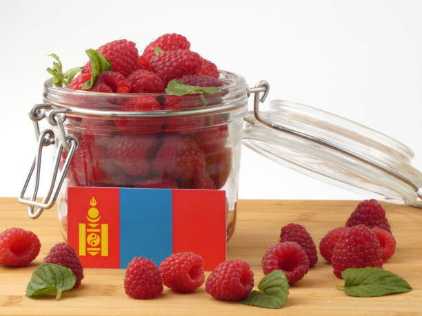 istock Mongolian flag on a wooden panel with raspberries isolated on a white background 843661368