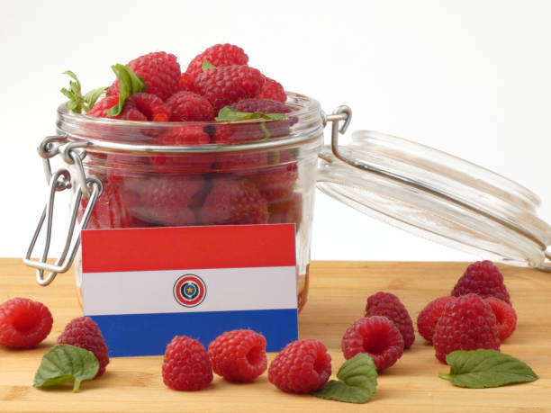 istock Paraguay flag on a wooden panel with raspberries isolated on a white background 843667210