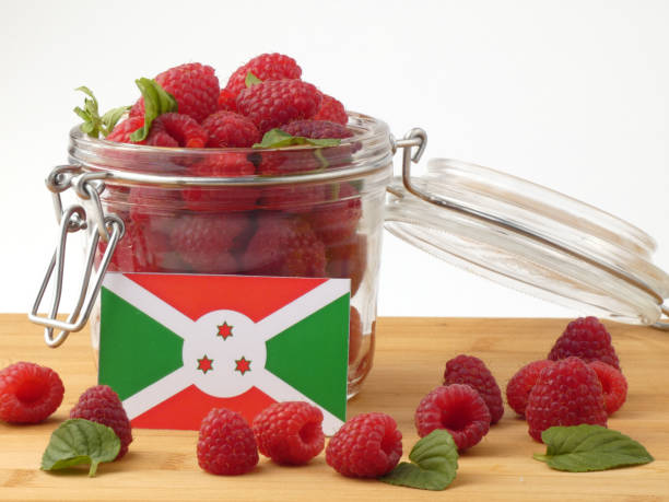istock Burundi flag on a wooden panel with raspberries isolated on a white background 843667412