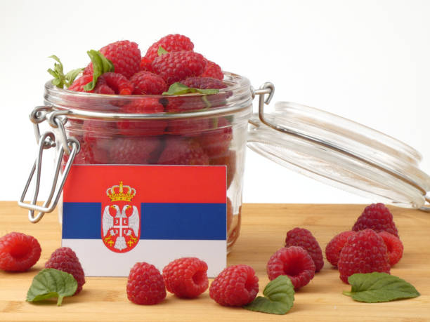 istock Serbian flag on a wooden panel with raspberries isolated on a white background 843669586