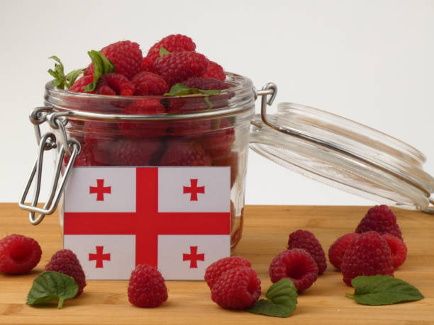 istock Georgian flag on a wooden panel with raspberries isolated on a white background 843671706