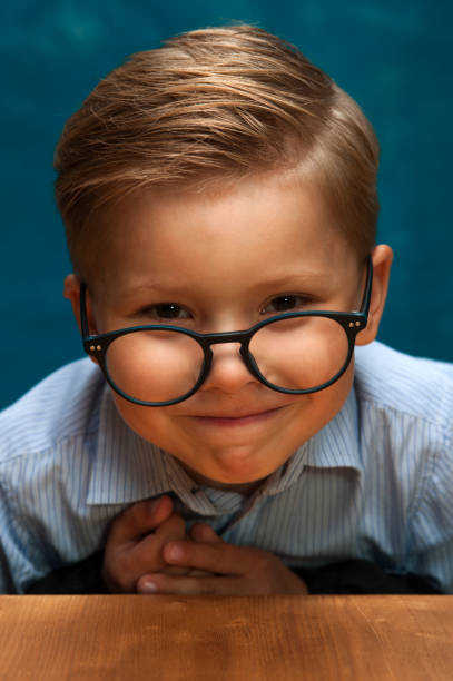 istock Smiling businessman child sitting at the table 843672052