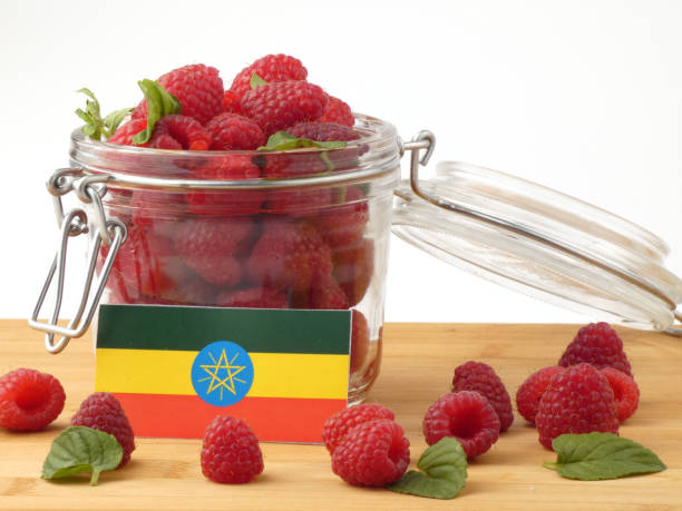 istock Ethiopian flag on a wooden panel with raspberries isolated on a white background 843672170