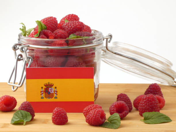 istock Spanish flag on a wooden panel with raspberries isolated on a white background 843672448