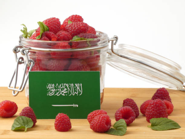 istock Saudi Arabian flag on a wooden panel with raspberries isolated on a white background 843672790