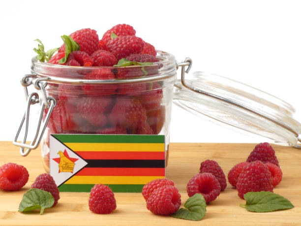 istock Zimbabwe flag on a wooden panel with raspberries isolated on a white background 843672798