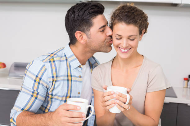istock Happy woman drinking coffee getting a kiss from partner 843672904