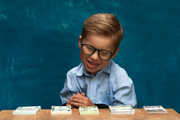 istock Little stylish boy counting money at workplace 843672918